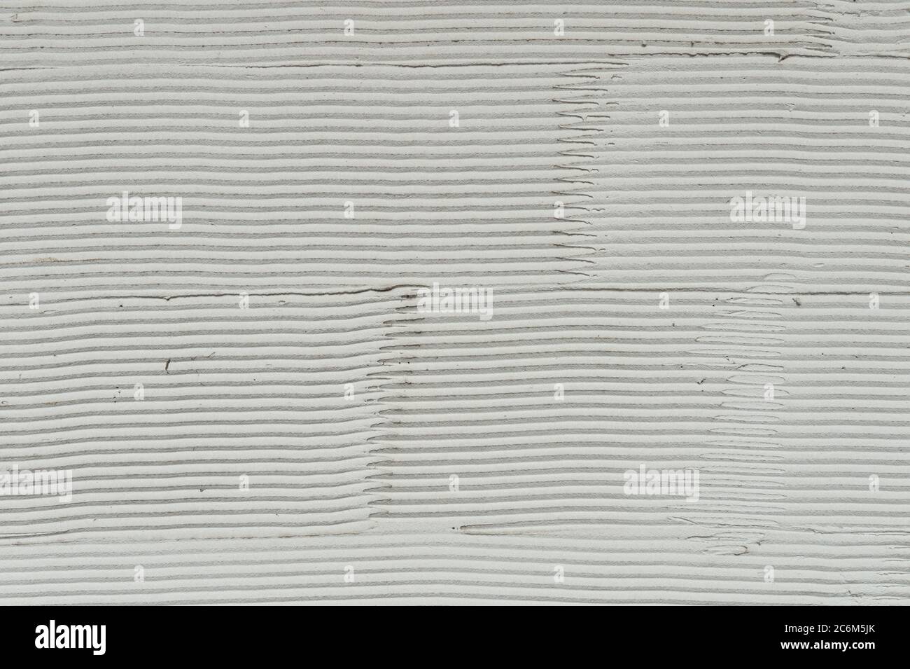 Fragment der Wand mit den Kratzern und den Rissen. Weißer Zement Hintergrund mit Mustern. Stockfoto