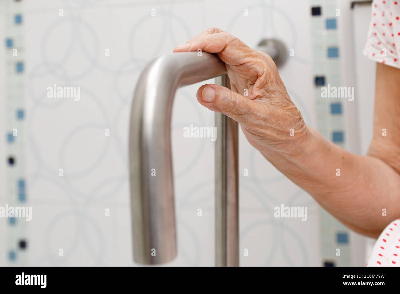 Ältere Frau Holding auf Handlauf in der Toilette. Stockfoto