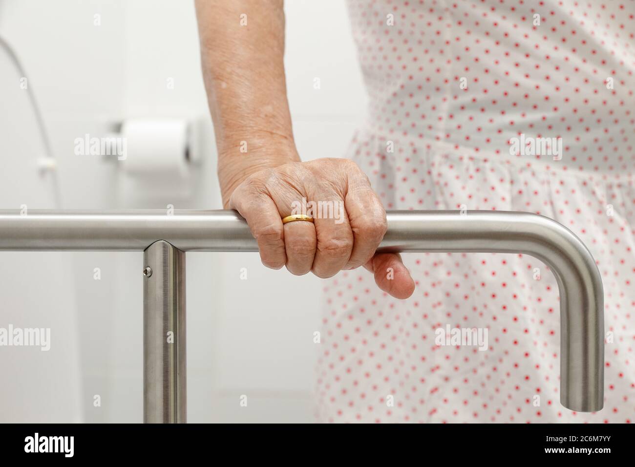 Ältere Frau Holding auf Handlauf in der Toilette. Stockfoto