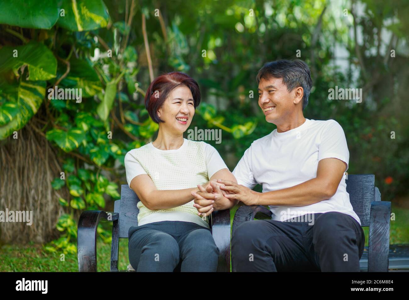 Paar mittleren Alters entspannen auf der Bank im Hinterhof sitzen. Stockfoto