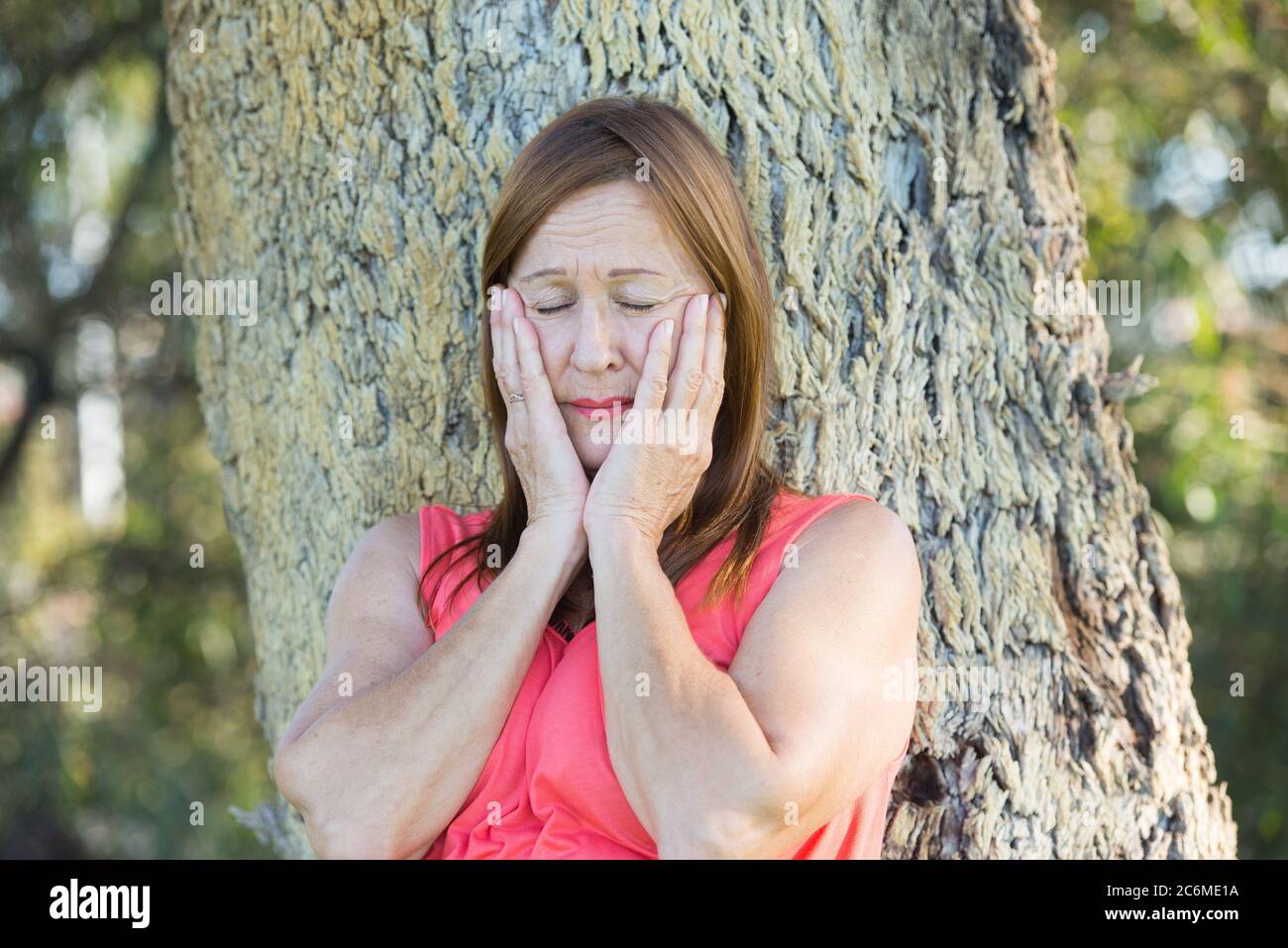 Portrait traurig und verwüstete reife Frau im Freien, mit geschlossenen Augen und gestressten Gesichtsausdruck. Stockfoto