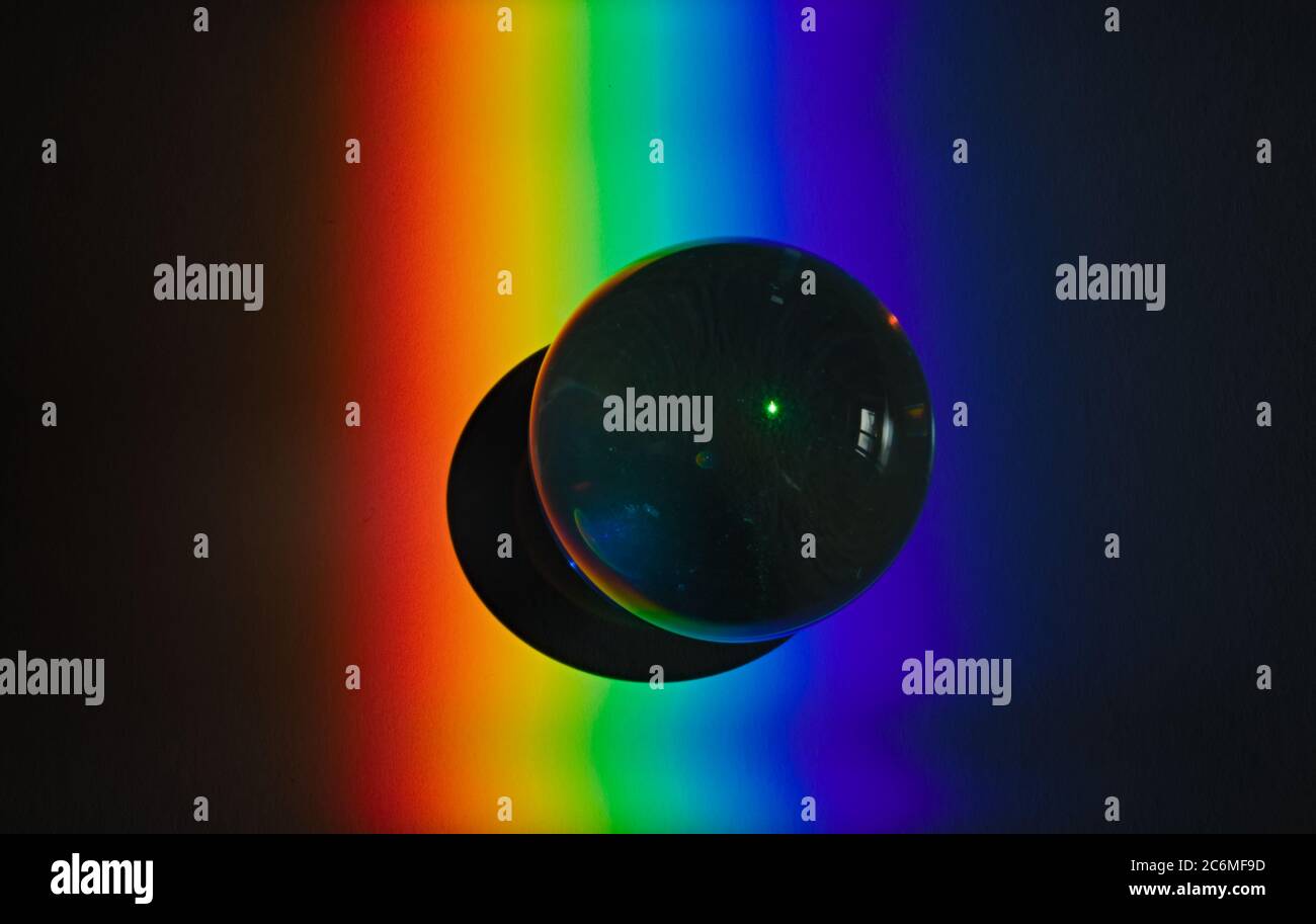 Farben des Regenbogenprodukts des gebrochenen Lichts, das das Spektrum des Lichts zeigt, das von einem sphärischen Glasobjekt Physik und Optik gebogen wird Stockfoto