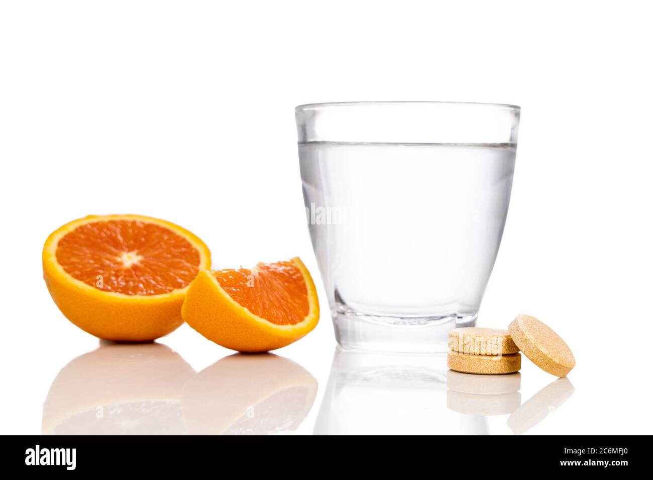 Glas Wasser mit Orangen und Vitamin C Brausetablette auf weißem Hintergrund Stockfoto