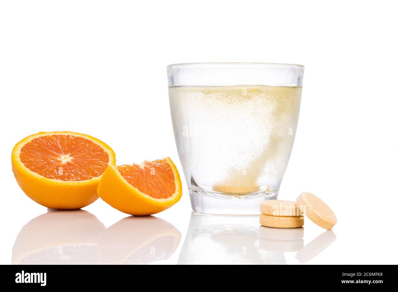 Serie von Orange aromatisierten Vitamin C Brausetablette fallen gelassen und lösen sich in Glas Wasser auf weißem Hintergrund Stockfoto
