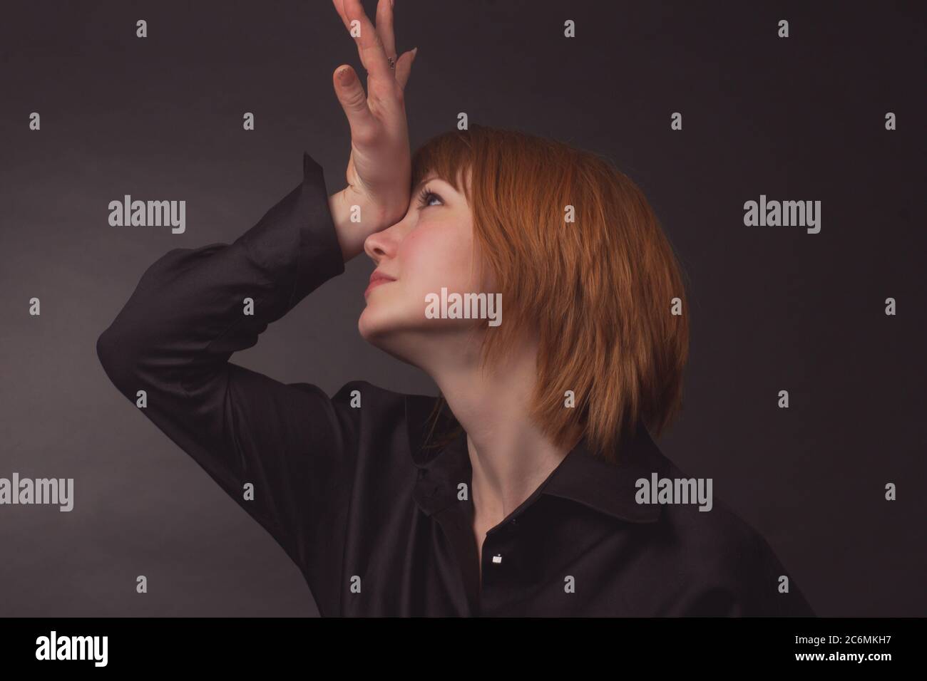 Studio-Portrait einer jungen lustigen Frau mit kurzen Haaren in einer schwarzen Bluse, Stockfoto