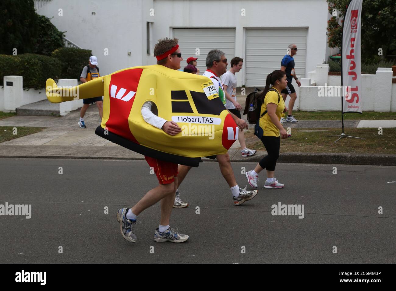 Einige Läufer haben Geld für den Rettungsdienst des Westpac Life Saver Helicopter gesammelt. Einige haben sich sogar als gelbe Westpac Life Saver Helicopters verkleidet. Stockfoto