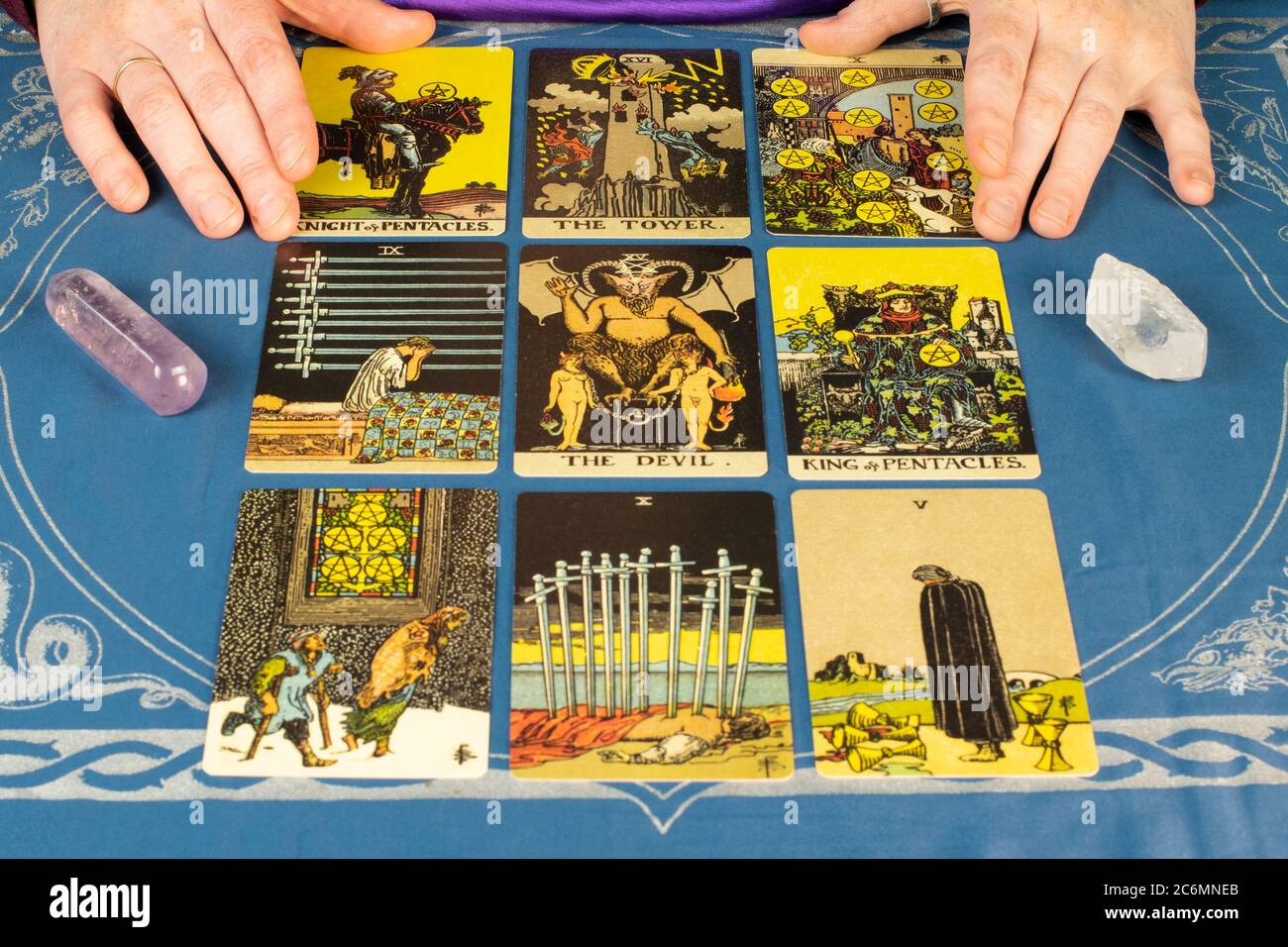 Tarot-Karten aus dem 1910 Rider-Waite Design. Tarot-Lesung mit Karten und Kristall mit Teufelskarte in der Mitte von neun Karten Stockfoto