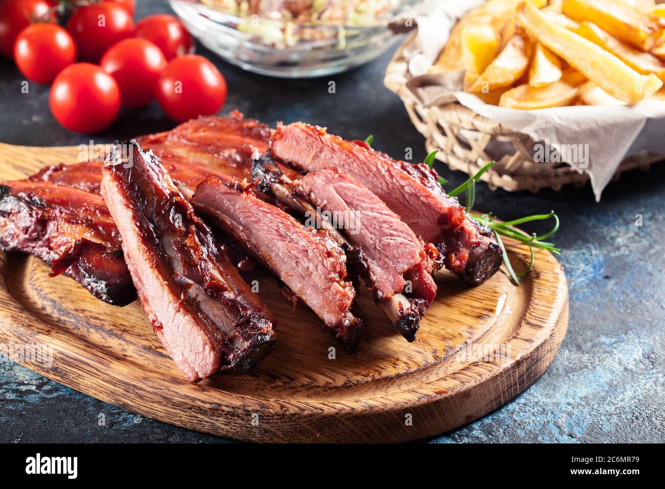 Würzige gegrillte Schweineribs mit BBQ-Sauce auf Schneidebrett serviert Stockfoto