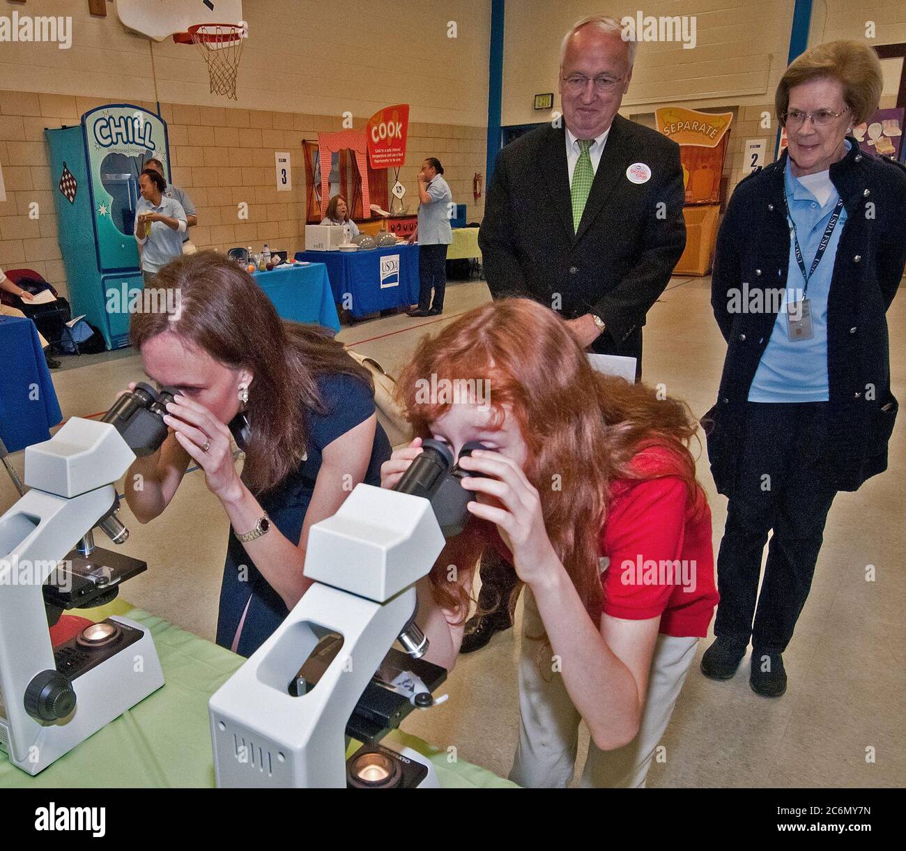 Dr. Elisabeth Hagen (links), Staatssekretärin der Lebensmittelsicherheit und Emily Wise (rechts), eine fünfte Klasse Student an Maryland Stadt Volksschule in Laurel, Maryland Blick durch Mikroskope Listerien und Salmonellen, zwei der vier häufigsten Bakterien in Lebensmitteln gefunden. Die beiden anderen Bakterium Campylobacter und E. coli. Hinter Hagen und Weisen sind Dr. Kevin Concannon, Staatssekretär Verbraucher und Ernährung Dienstleistungen und Barbara Robinson, Food Safety Inspection Service. Die FSIS hielt eine Lebensmittelsicherheit Ausbildung Lager bei Maryland Stadt Volksschule, Do., 5. Mai 2011 Stockfoto