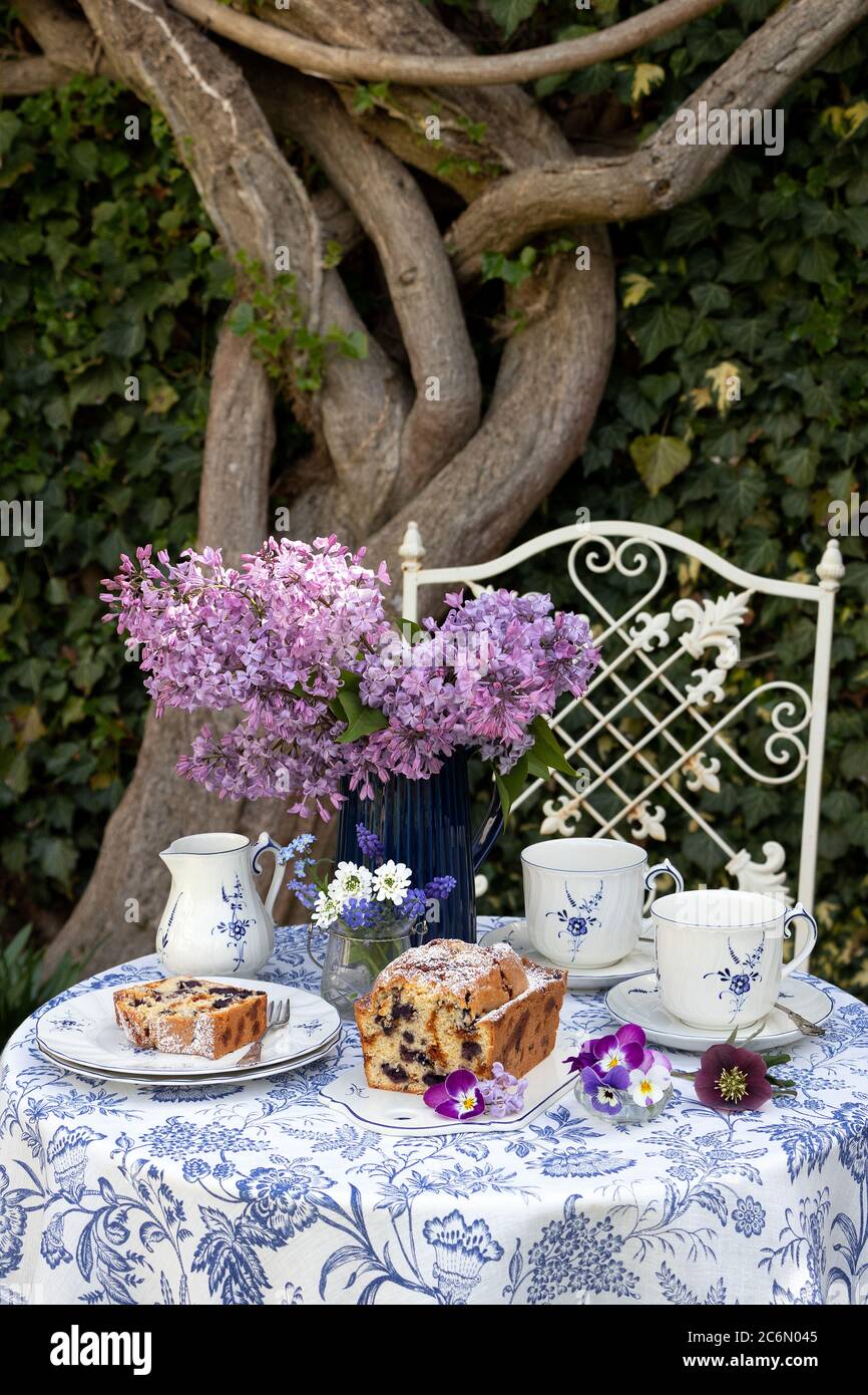 Tischdekoration mit Heidelbeerkuchen und einem Blumenstrauß aus Flieder Stockfoto