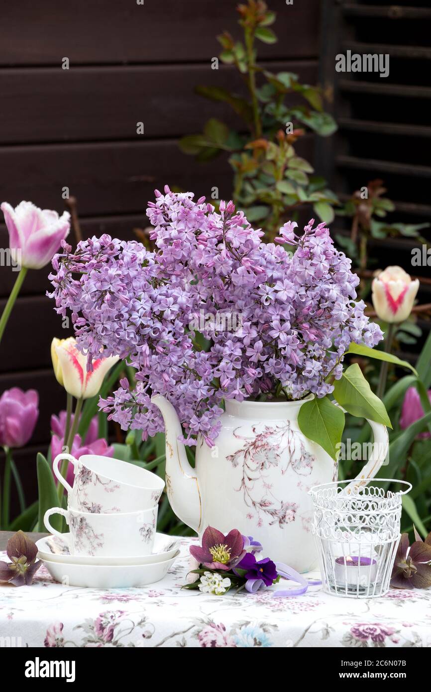 Tischdecoratio mit Blumenstrauß Flieder und Vintage Porzellan Stockfoto