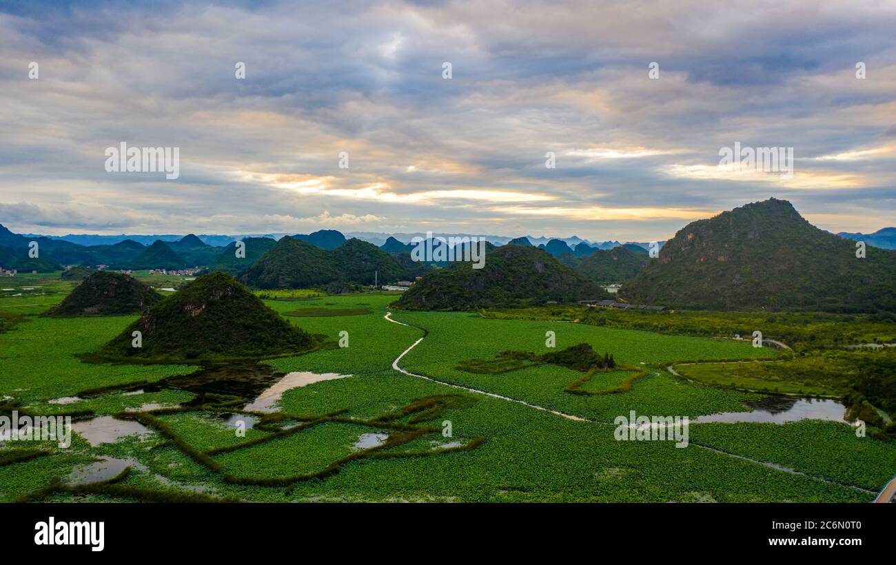 (200711) -- QIUBEI, 11. Juli 2020 (Xinhua) -- Luftfoto vom 8. Juli 2020 zeigt die Sonnenuntergangsszenerie im Puzhehei National-Feuchtgebiet-Park im Qiubei-Bezirk in der südwestlichen chinesischen Provinz Yunnan. (Xinhua/Hu Chao) Stockfoto