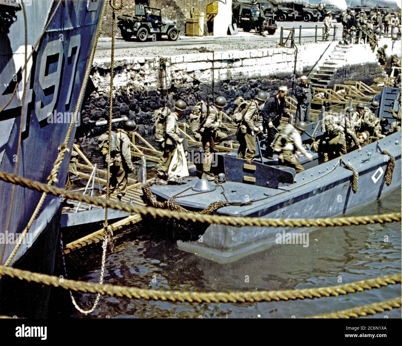 Die amerikanischen Truppen in einen britischen Hafen steigen in Bargen, das Sie an Truppe Schiffe, von denen Sie den Angriff gegen Hitlers Festung Europa starten. Hinweis Barrage Luftballons im Hintergrund. Stockfoto