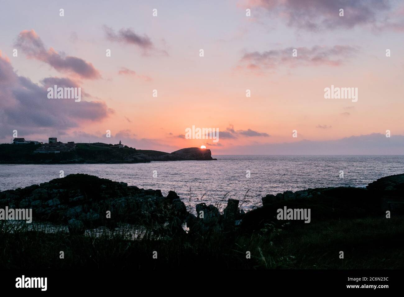 Sonnenuntergang an der Küste mit einigen schönen Wolken. Stockfoto
