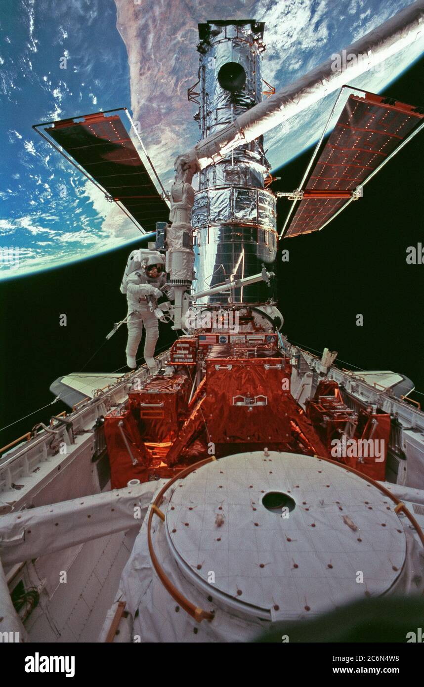 (15. Februar 1997) --- Diese breite Aufnahme des Hubble Space Telescope (HST) in Discovery's Cargo Bay, wurde gegen Australien zurückfallen gelassen, während der dritten STS-82 Spacewalk aufgenommen, um das Observatorium in der Umlaufbahn zu instand zu setzen. Astronaut Steven L. Smith (links von der Mitte) arbeitet in der Nähe der Fußstütze des Remote Manipulator Systems (RMS). Astronaut Mark C. Lee, Nutzlastkommandant, der mit Smith die Aufgaben des Weltraumspaziergangs teilte, war aus dem Rahmen. Stockfoto