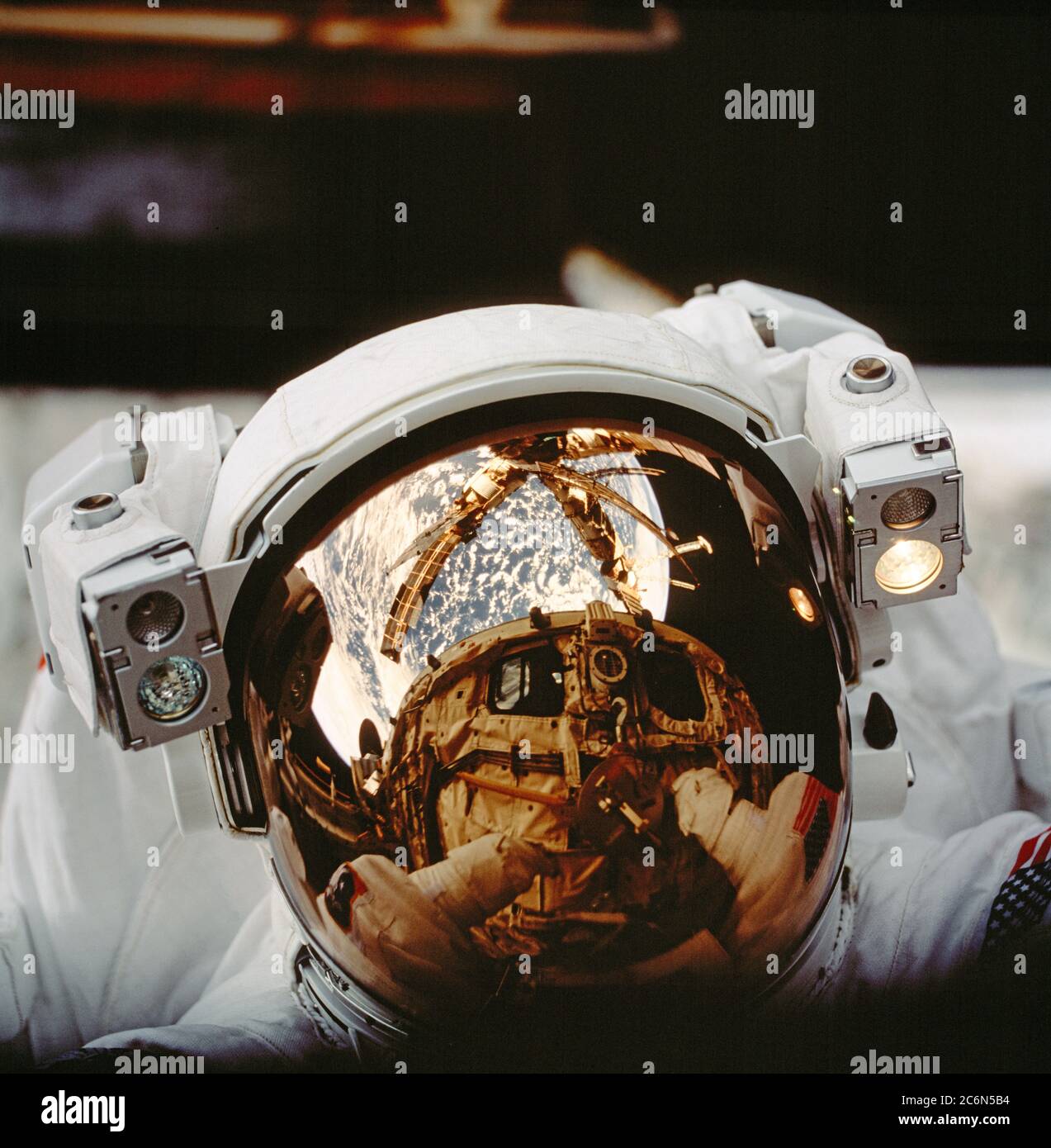 (25. September-6. Oktober 1997) --- das Helmvisier von Astronaut Scott Parazynski reflektiert die Raumfähre Atlantis' Frachtraum-Bucht und Russlands mir-Raumstation sowie den Erdhorizont. Die Astronauten Parazynski und Vladimir G. Titov, beide STS-86-Missionsspezialisten, verbrachten mehrere Stunden damit, mir Environmental Effects Packages (MEEP) zu finden, die seit September 1996 der Weltraumumgebung um das permanente Docking Module (DM) von mir ausgesetzt waren. Titov vertritt die Russische Raumfahrtbehörde (RSA). Stockfoto