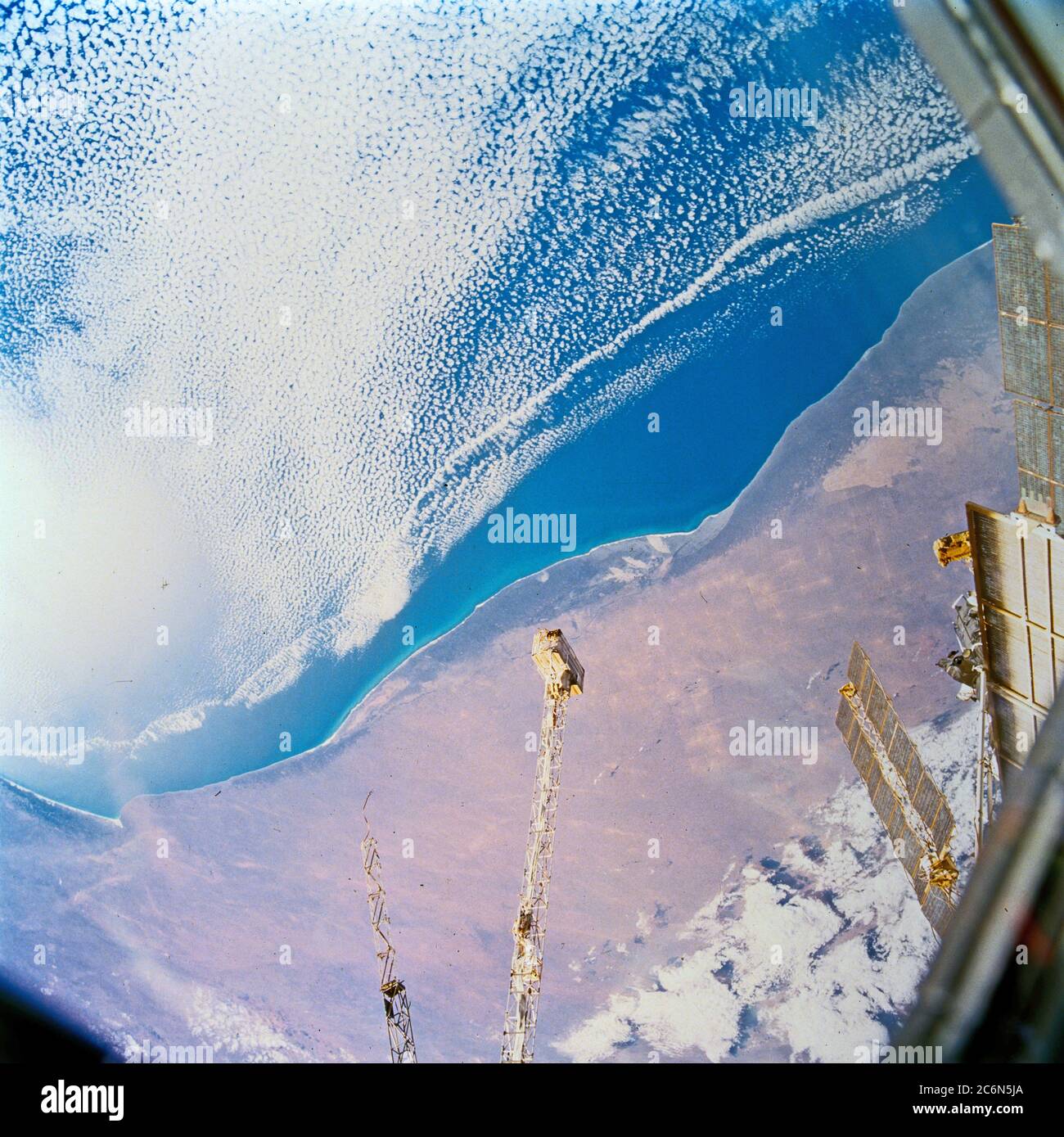(22-32. Januar 1998) --- Dieses Bild von Südaustralien wurde mit einer 70mm-Handkamera des erdumkreisenden Raumshuttles Endeavour fotografiert. Die Nullarbor-Ebene (hinter dem Boom der russischen Raumstation mir) war eines der am wenigsten fotografierten Merkmale der Kontinente. Die Küstenabfahrt steigt abrupt auf 500 Meter über dem Meeresspiegel. Das Kalksteinfundament wurde entlang von Brüchen und Gelenken aufgelöst. Auf diesem Foto der Western Australian Bight sind Lösungsrillen zu sehen, die lokalisierte Sandablagerungen in langen Bändern haben. Sowohl im Inland als auch entlang der Küste, abgerundete sinkhol Stockfoto