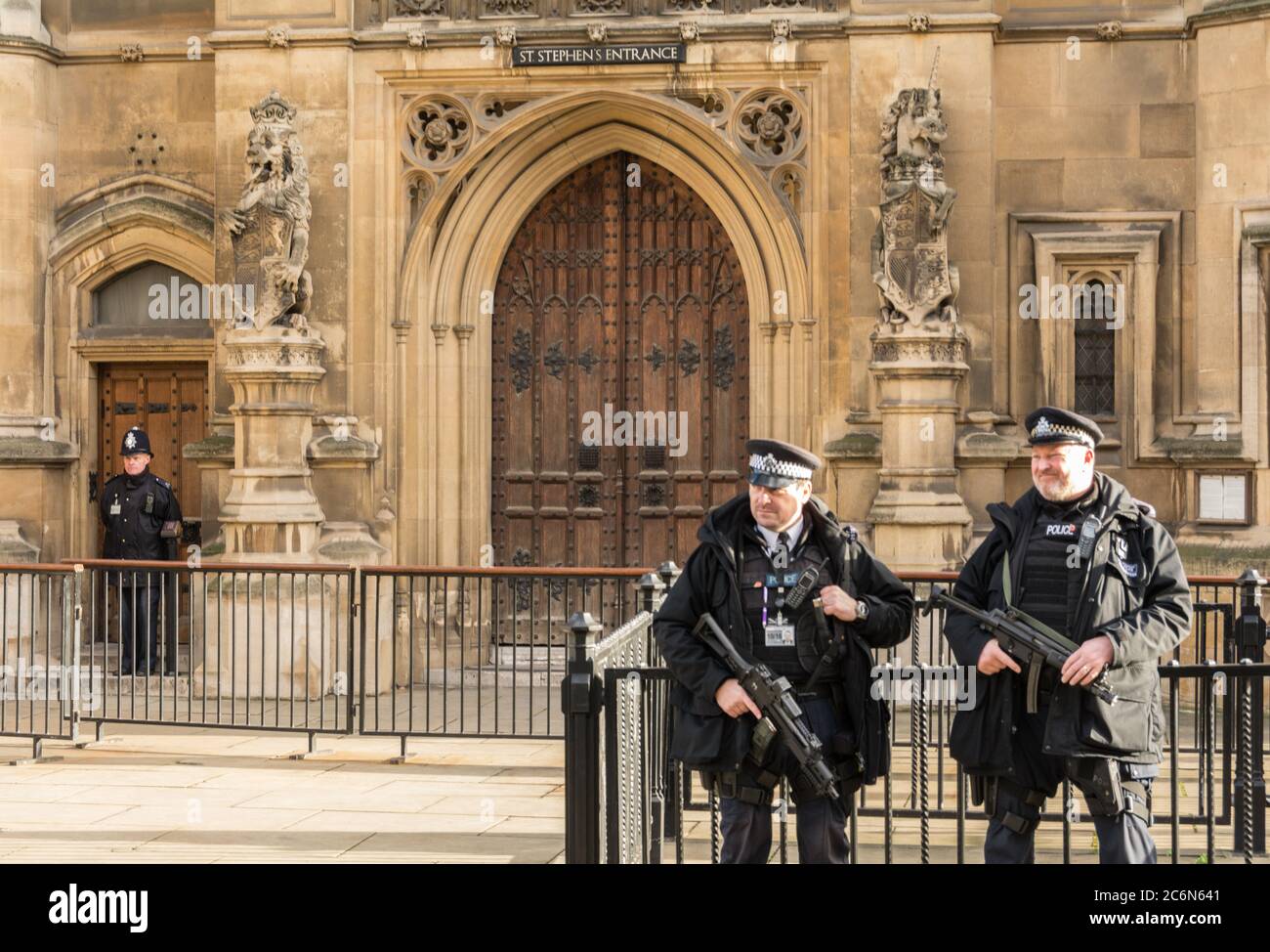 Die bewaffnete Polizei des diplomatischen Schutzes steht vor St. Stephen's Eingang zu den Houses of Parliament, Westminster, London, England, Großbritannien Stockfoto