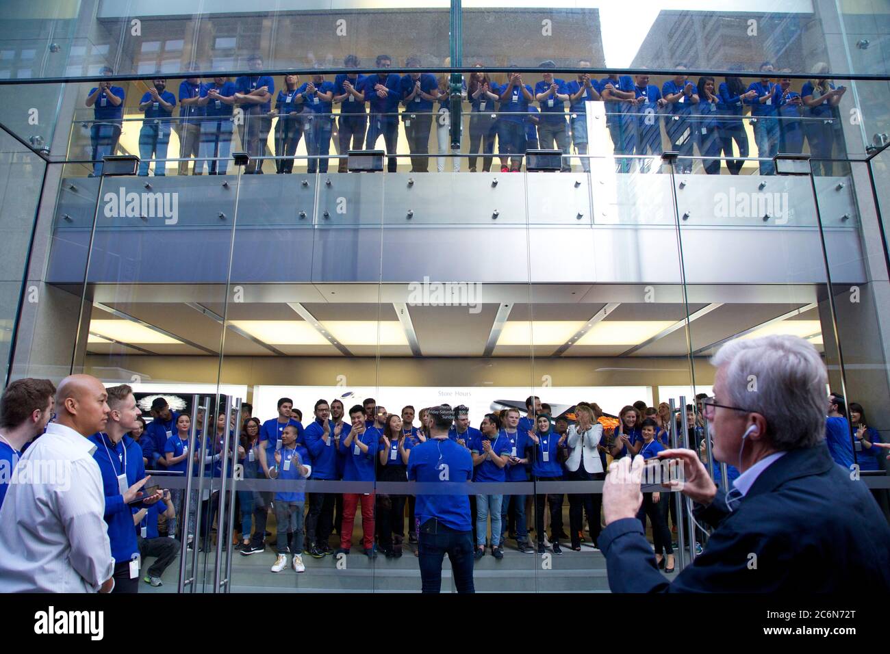 Mitarbeiter im Apple Store stehen in den verschiedenen Etagen in der Nähe der Fenster an, um die ersten Kunden für das iPhone 6 in den einzulassen Stockfoto