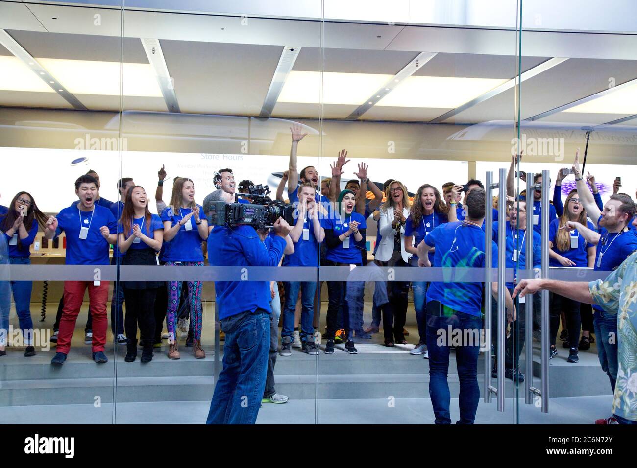 Mitarbeiter im Apple Store stehen in den verschiedenen Etagen in der Nähe der Fenster an, um die ersten Kunden für das iPhone 6 in den einzulassen Stockfoto