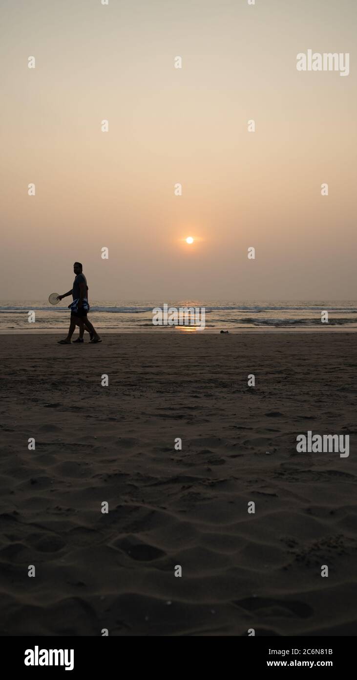 Sonnenuntergang über Meer und Strand. Wolkenloser Sonnenuntergang Himmel über winkenden Meer und Sandstrand am Abend im Resort Stockfoto