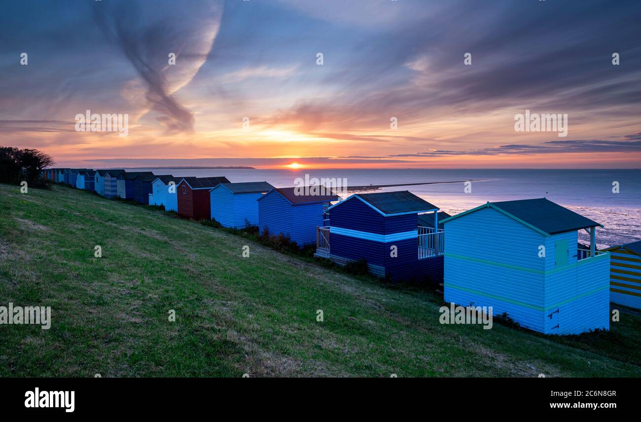 Eine Kent-Küste-Szene; Whitstable Strandhütten auf Tankerton Hängen bei Sonnenuntergang. Stockfoto