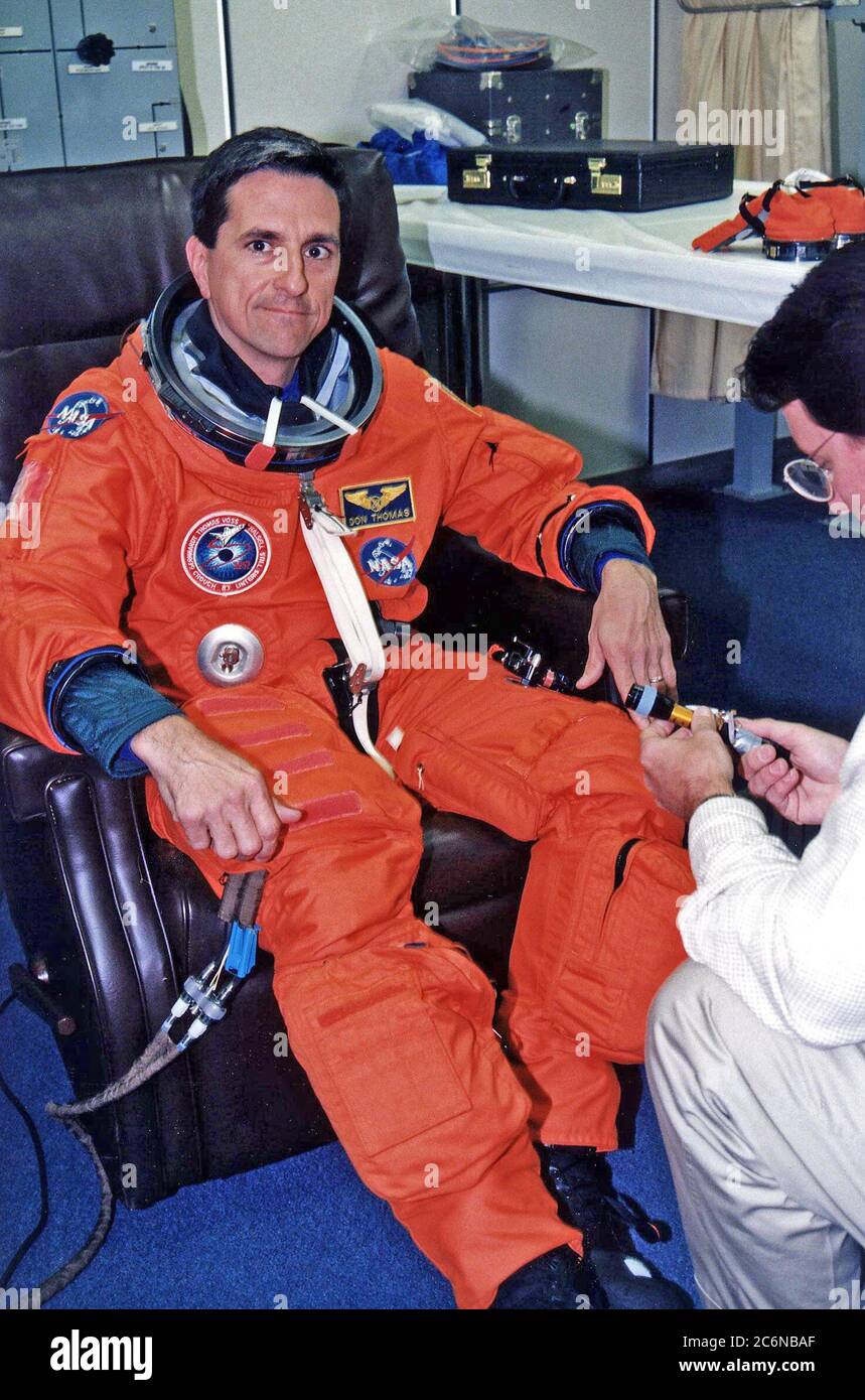 STS-83 Mission Specialist Donald A. Thomas wird bei seinem Start-/Einstiegssachen im Operations and Checkout (O&C) Building unterstützt. Er ist sowohl mit STS-70 als auch mit STS-65 geflogen. Er hat einen Doktortitel in Materialwissenschaften und war der Principal Investigator für ein Space Shuttle Kristallwachstum Experiment. Stockfoto