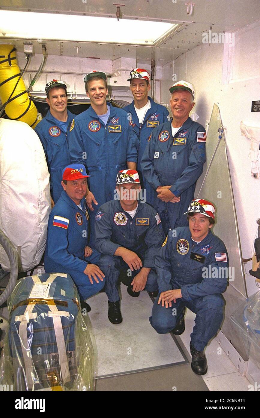 STS-86 Crew-Mitglieder posieren für ein Gruppenfoto vor der Luke zur Crew-Kabine des Space Shuttle Atlantis auf dem Launch Pad 39A. Vor ihm knien von links die Missionsspezialisten Vladimir Georgievich Titov von der russischen Weltraumorganisation, David A. Wolf und Wendy B. Lawrence. Von links stehen Pilot Michael J. Bloomfield, Missionsspezialist Scott E. Parazynski, Kommandant James D. Wetherbee und Missionsspezialist Jean-Loup J.M. Chretien der französischen Raumfahrtagentur CNES. Stockfoto