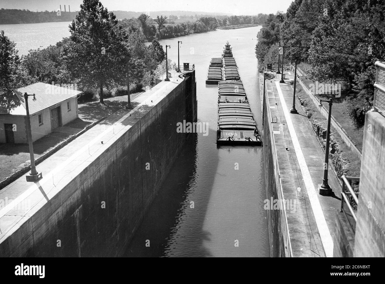 Arrow Transportation Company Diesel Schleppboot ATCO betritt Wilson Lock 5. Oktober 1946 auf Tennessee River Mile 259.4 in Florence, Ala. Die sechs Barger enthielten etwa 4,000 Tonnen Getreide aus St. Louis, Mo., geleitet zu Decatur und Guntersville, Ala. Das U.S. Army Corps of Engineers Nashville District betreibt und pflegt die Schleuse beim Tennessee Valley Authority Projekt Stockfoto