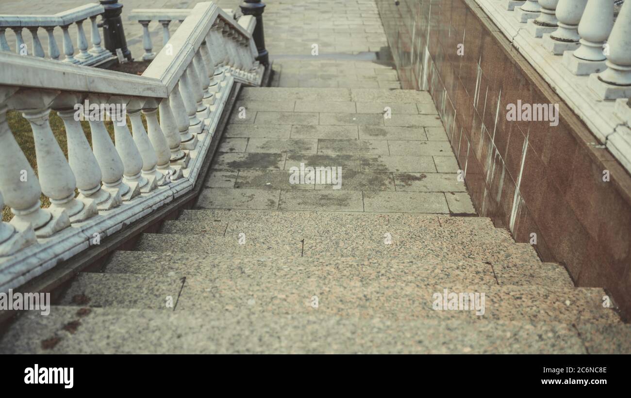 Nahaufnahme der Betontreppe mit Geländern. Steintreppe im Freien im Stadtpark. Stockfoto