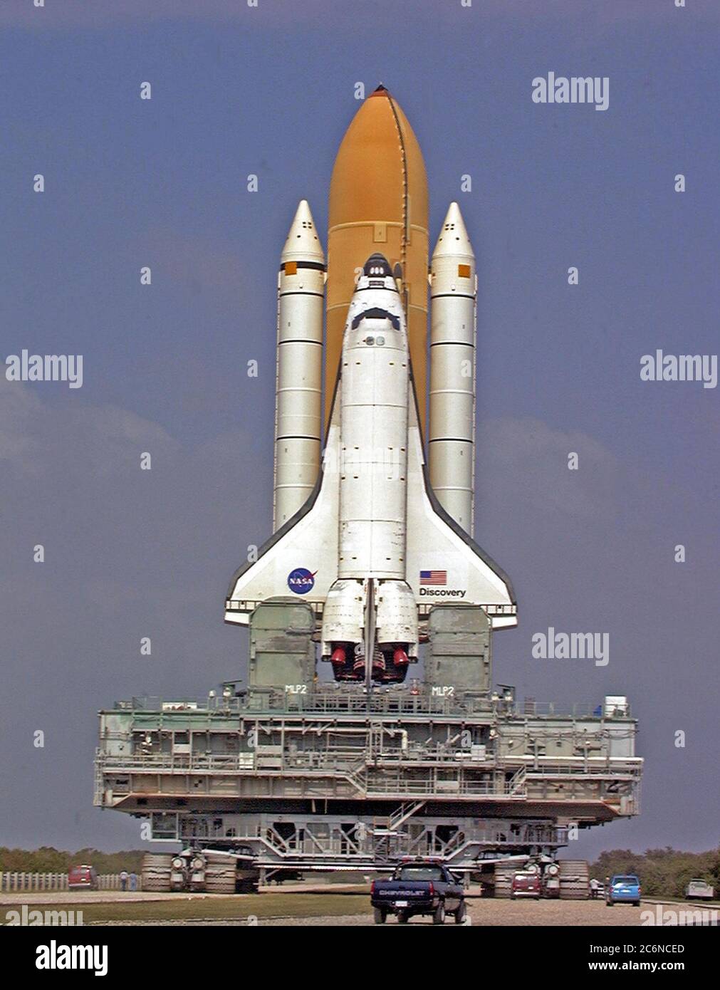 Auf der mobilen Trägerplattform und dem Crawler-Transporter thront Space Shuttle Discovery, der auf seinem Weg vom Vehicle Assembly Building zum Launch Pad 39B eine Wende im Crawlerway aushandelt. Während der Zeit auf dem Pad werden Orbiter, externer Tank und solide Raketenverstärker den letzten Vorbereitungen für den STS-103 Start unterzogen, der für den 6. Dezember 1999 um 2:37 Uhr EST geplant ist. Stockfoto