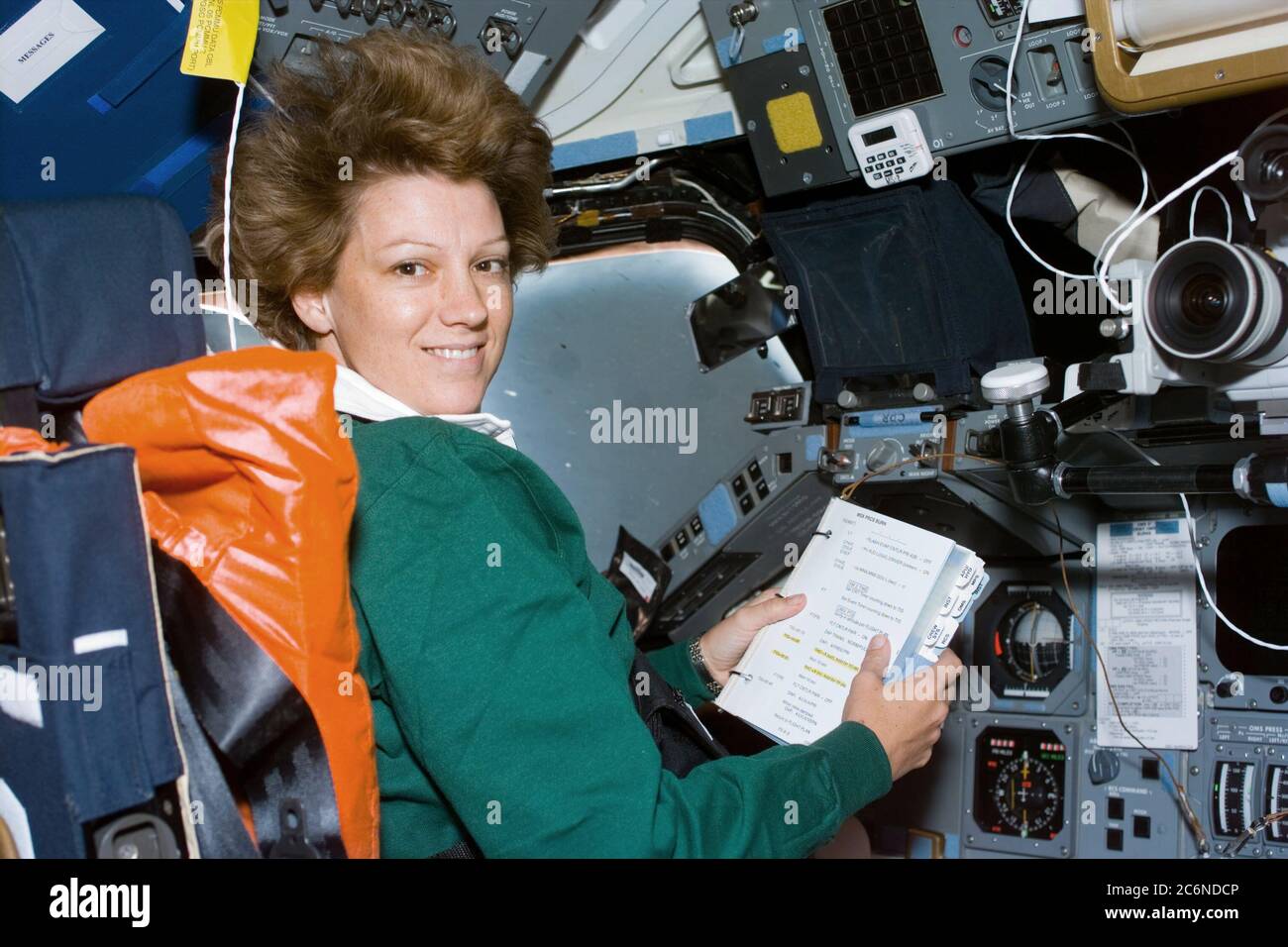 (23. Juli 1999) --- Astronaut Eileen M. Collins, Missionskommandant, schaut sich am Flugtag 1 eine Prozedurscheckliste an der Kommandantenstation auf dem Vorwärtsflugdeck des Space Shuttle Columbia an. Das wichtigste Ereignis an diesem Tag war der Einsatz des Chandra-Röntgenobservatoriums, des weltweit leistungsstärksten Röntgenteleskops. Stockfoto