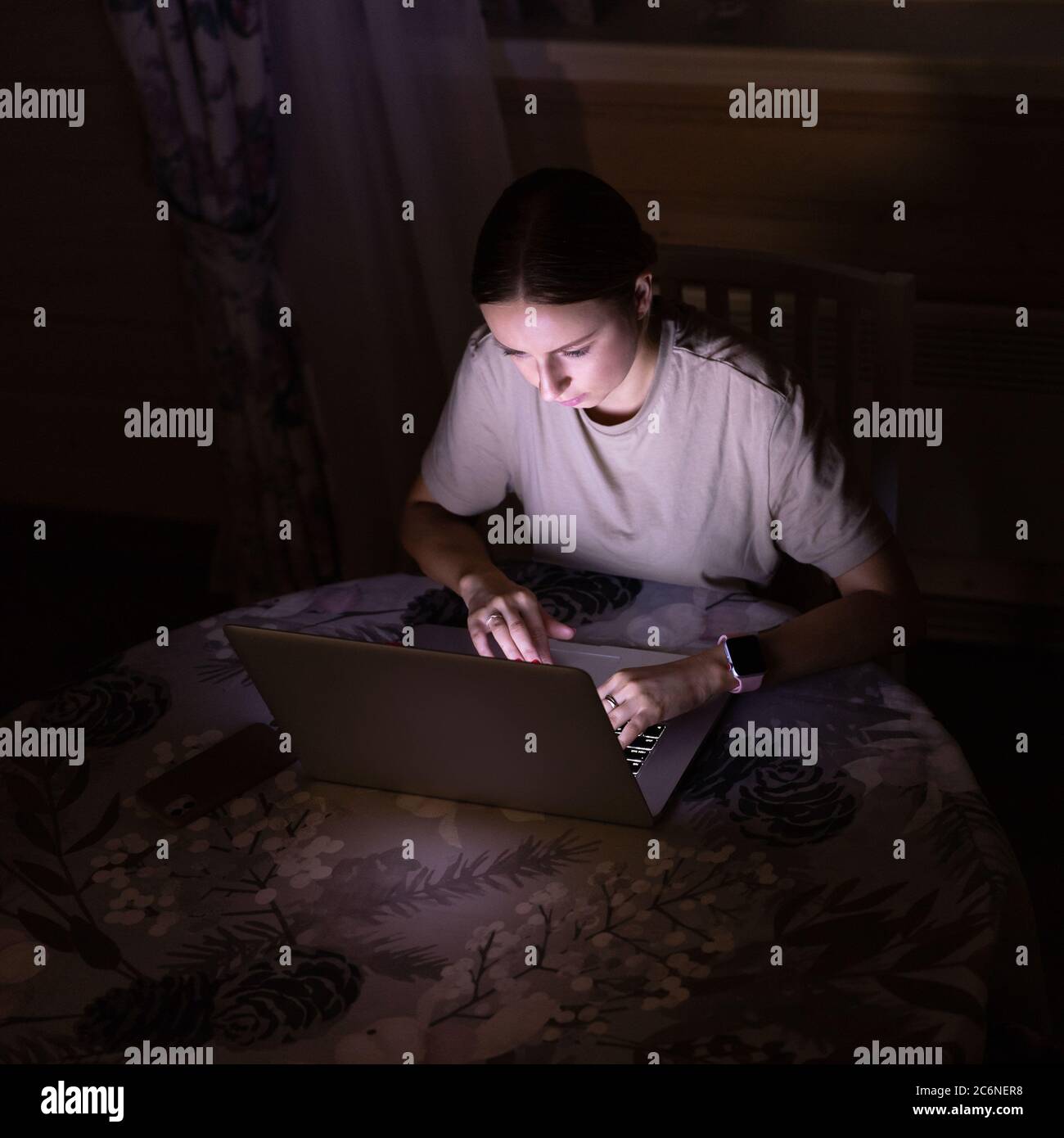 Freiberufliche Mitarbeiterin, die spät abends zu Hause am Laptop arbeitet und soziale Medien teilt. Distanzauftrag Stockfoto