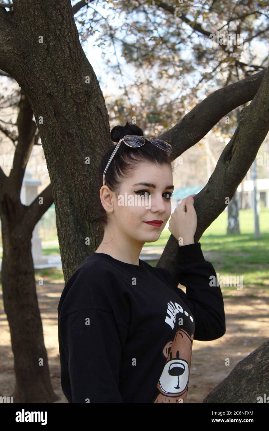 Porträt eines jungen Mädchens vor einem Baum draußen Stockfoto