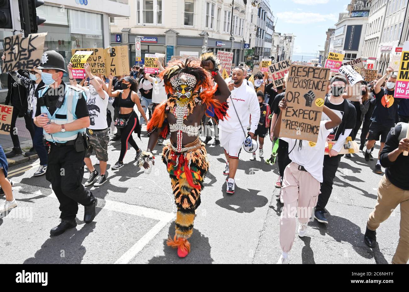 Brighton UK 11. Juli 2020 - Palaye Seck in traditioneller senegalesischer Tracht führt Tausende von Demonstranten in die Black Lives Matter Anti-Rassismus-Kundgebung in Brighton heute beginnend an der Küste vor dem Marsch durch das Stadtzentrum . Es gab Proteste in ganz Amerika, Großbritannien und anderen Ländern seit dem Tod von George Floyd, während er von der Polizei in Minneapolis am 25. Mai verhaftet : Credit Simon Dack / Alamy Live News Stockfoto