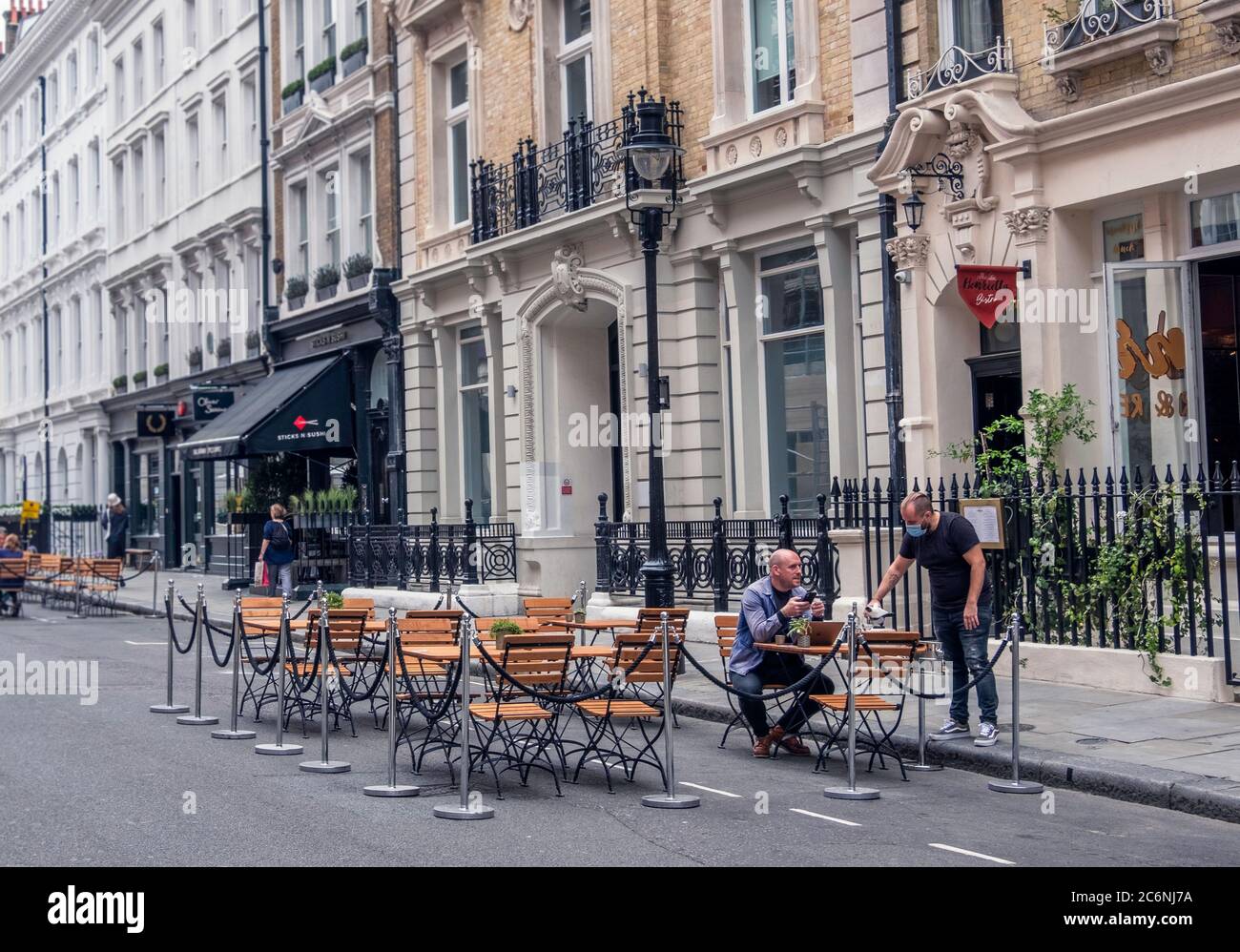 Ein Mann, der während der Pandemie des Covid-19 vor einem Restaurant in Covent Garden, London, serviert wurde. Stockfoto