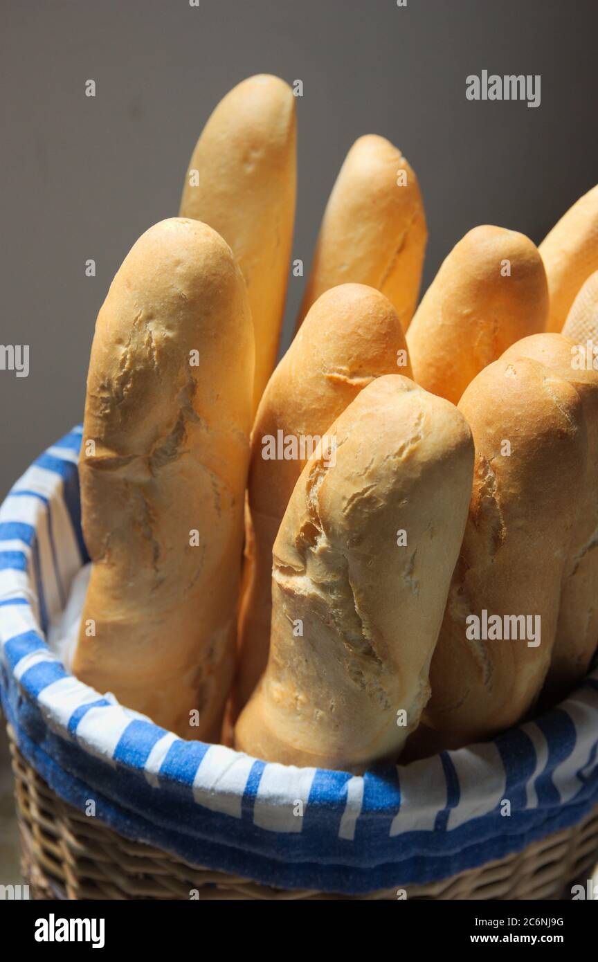 Weidenkorb, in dem es mehrere Brote aus weißem Mehl Brot das ganze Set isoliert auf einem neutralen Hintergrund Stockfoto