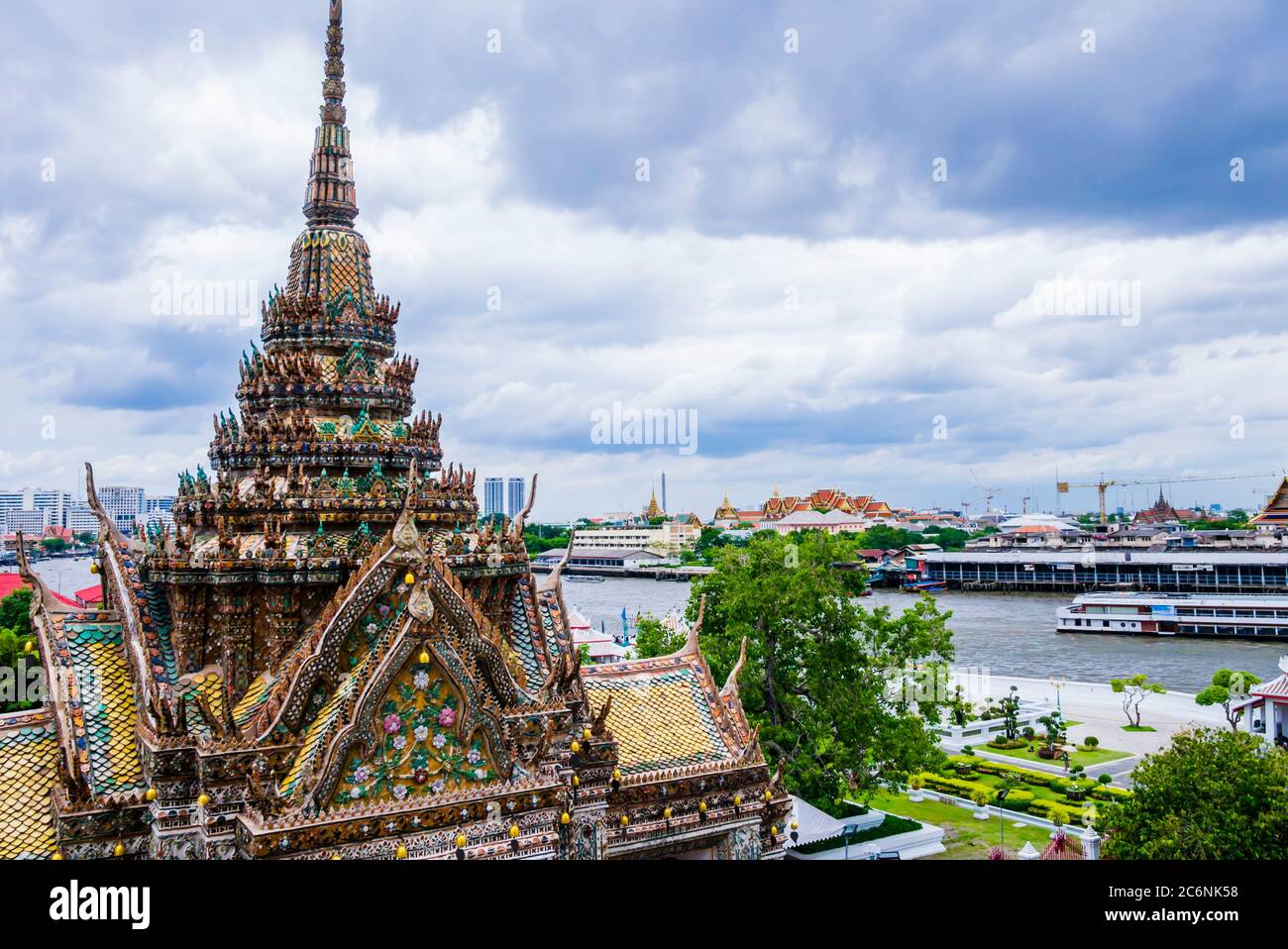 Atemberaubende Aussicht auf Pagode mit bunten Fliesen im Wat Arun Komplex, mit Chao Phraya Fluss im Hintergrund, Bangkok, Thailand Stockfoto