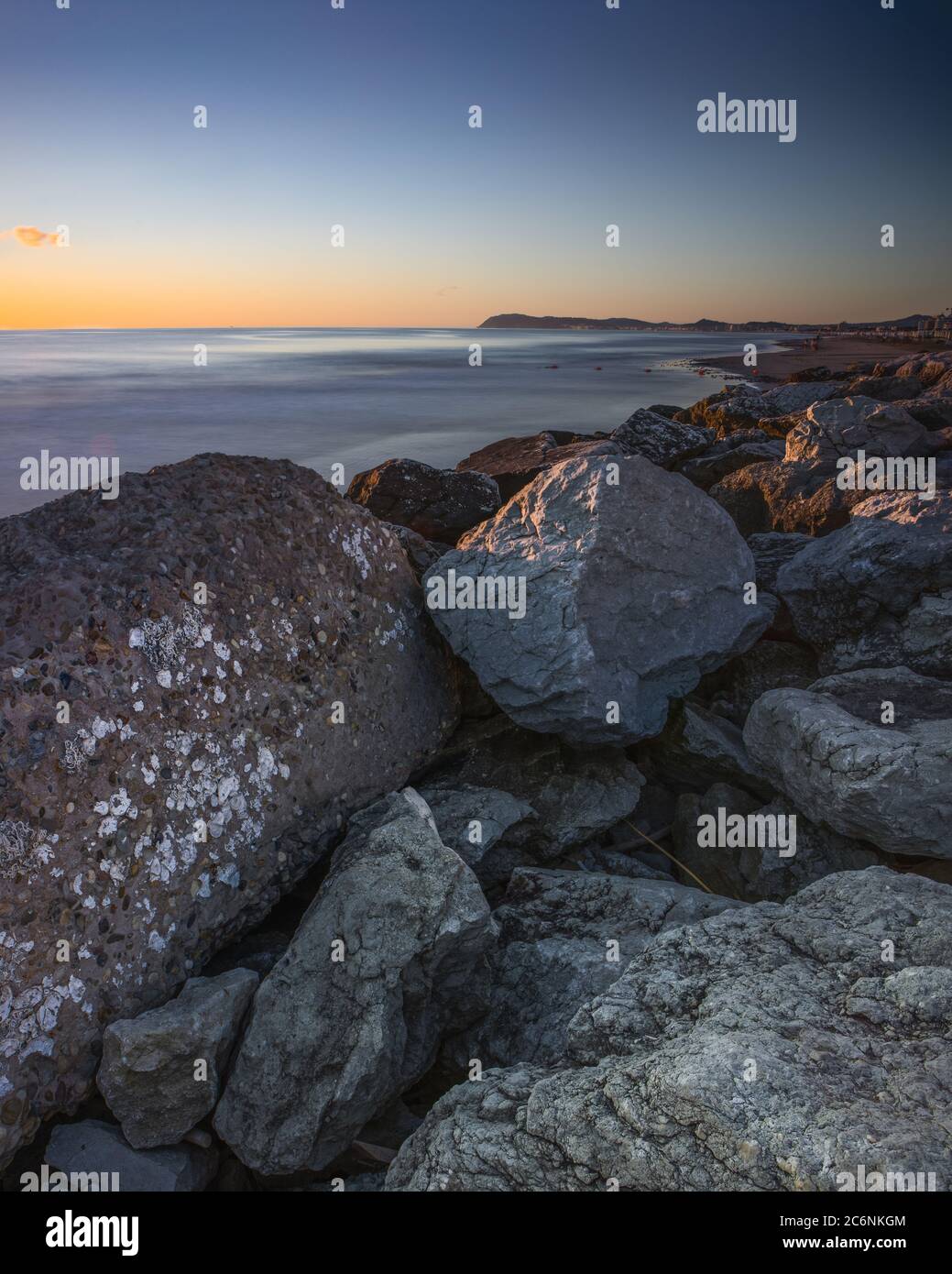 Landschaftlich schöner Blick auf Monte San Bartolo und Gabicce vom Strand von Riccione bei Sonnenaufgang, in Italien Stockfoto