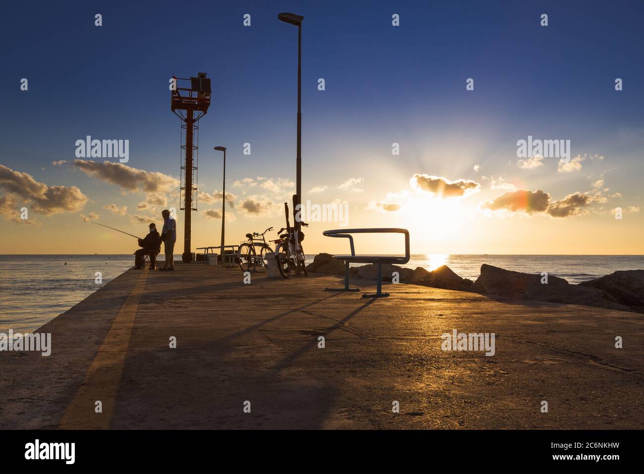 Zwei Fischer im Hafen von Riccione an der Adria bei Sonnenaufgang im Sommer Stockfoto