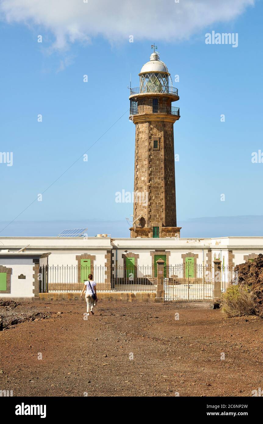 Junge Wanderfrau erreicht Leuchtturm Faro de Orchilla bei 1634 Meridian (Punta de la Orchilla, El Hierro Insel, Kanarische Inseln, Spanien) Stockfoto