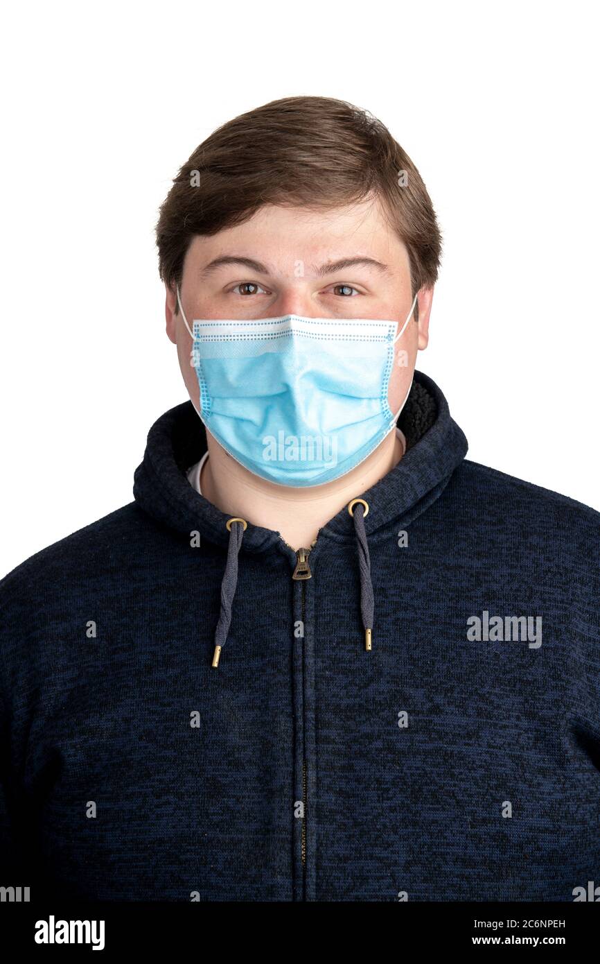 Weißer Mann mit einer medizinischen Einwegmaske und einer blauen Kapuzenjacke Stockfoto