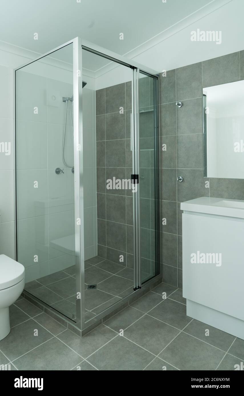 Neues grau-weißes Bad mit gefliesten Wänden und Boden Stockfoto