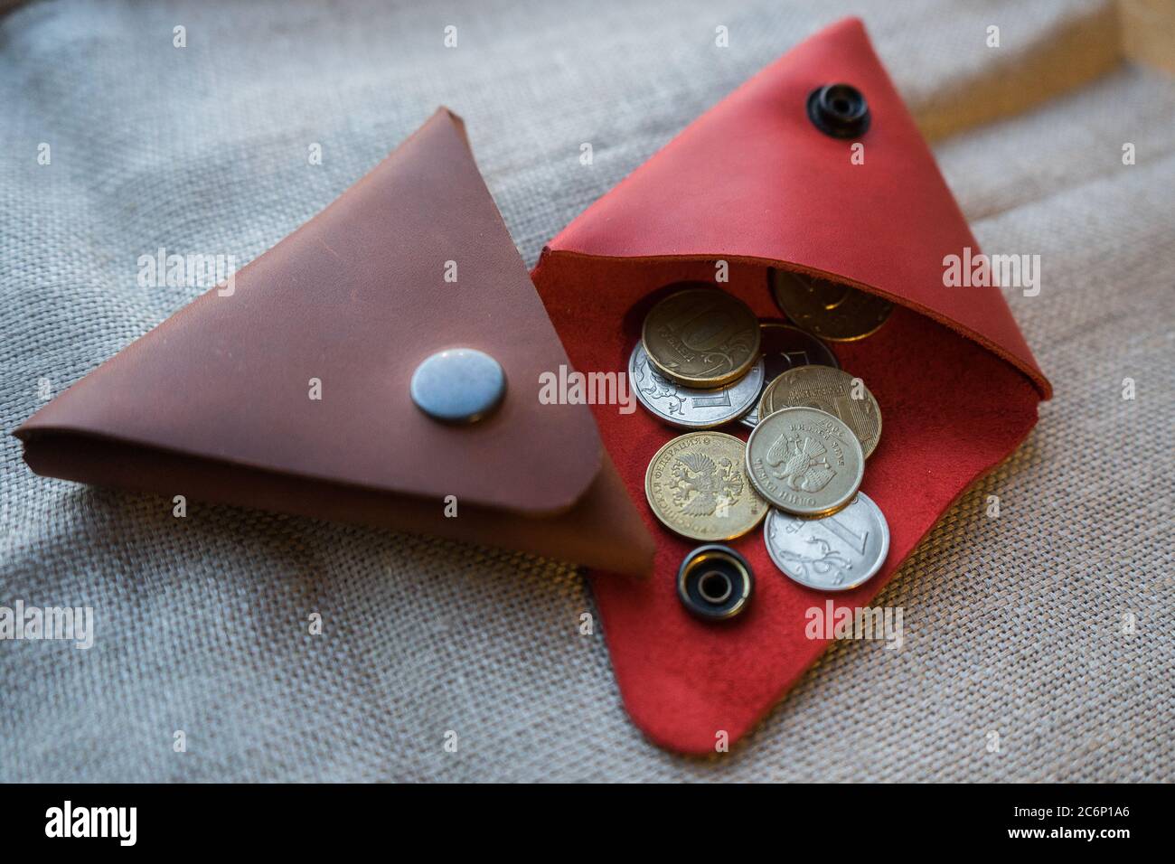 Handgemachte rote und braune Lederbörse für Münzen. Dreieckige Ledermünzbox. Stockfoto