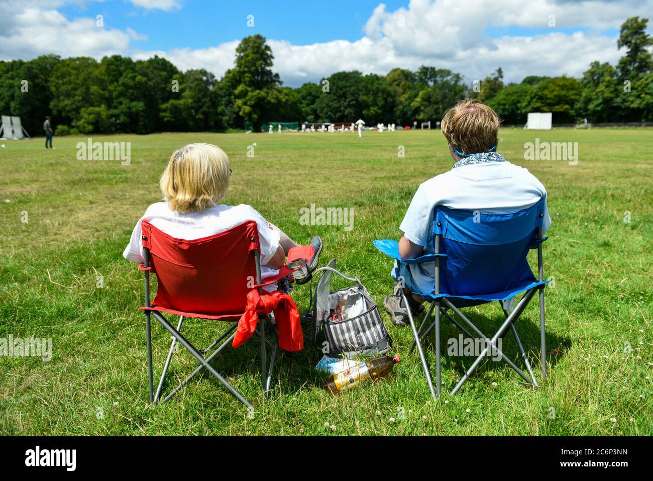 Chorleywood, Großbritannien. 11. Juli 2020. Anwohner beobachten Mitglieder des Chorleywood Cricket Club in ihrem ersten Freundschaftsspiel, nachdem die britische Regierung die Einschränkungen für die Sperrung mehrerer Outdoor-Aktivitäten durch Coronavirus-Pandemieviren gelockert hat. Der Amateurclub spielt seit fast 200 Jahren auf dem Common in Chorleywood in Hertfordshire. Kredit: Stephen Chung / Alamy Live Nachrichten Stockfoto