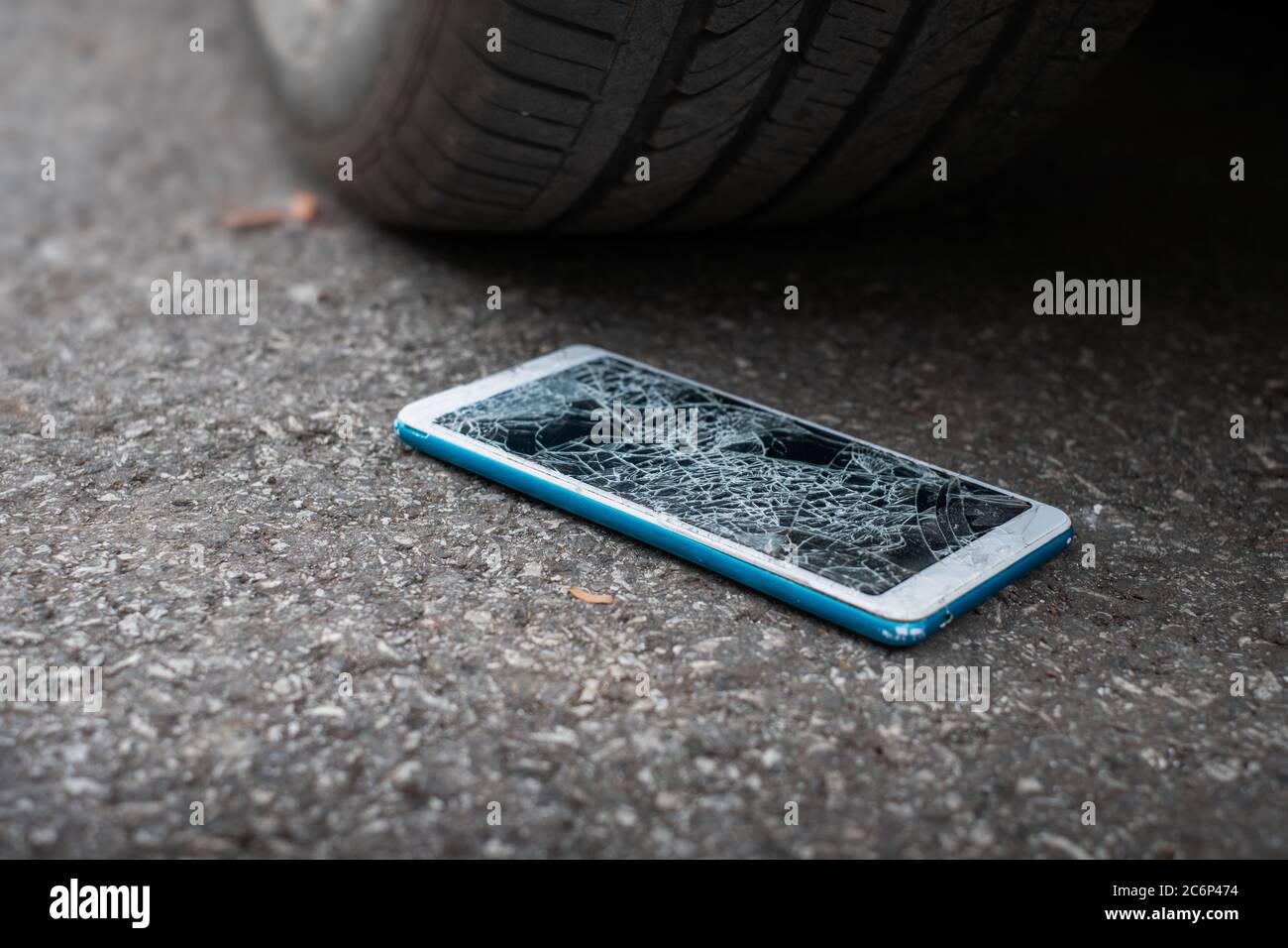 Smartphone-Bildschirm ist platt auf der Straße von Bewegung eines Autoreifen  auf der Vorder-und Rückseite Hintergrund ist verschwommen geknackt  Stockfotografie - Alamy