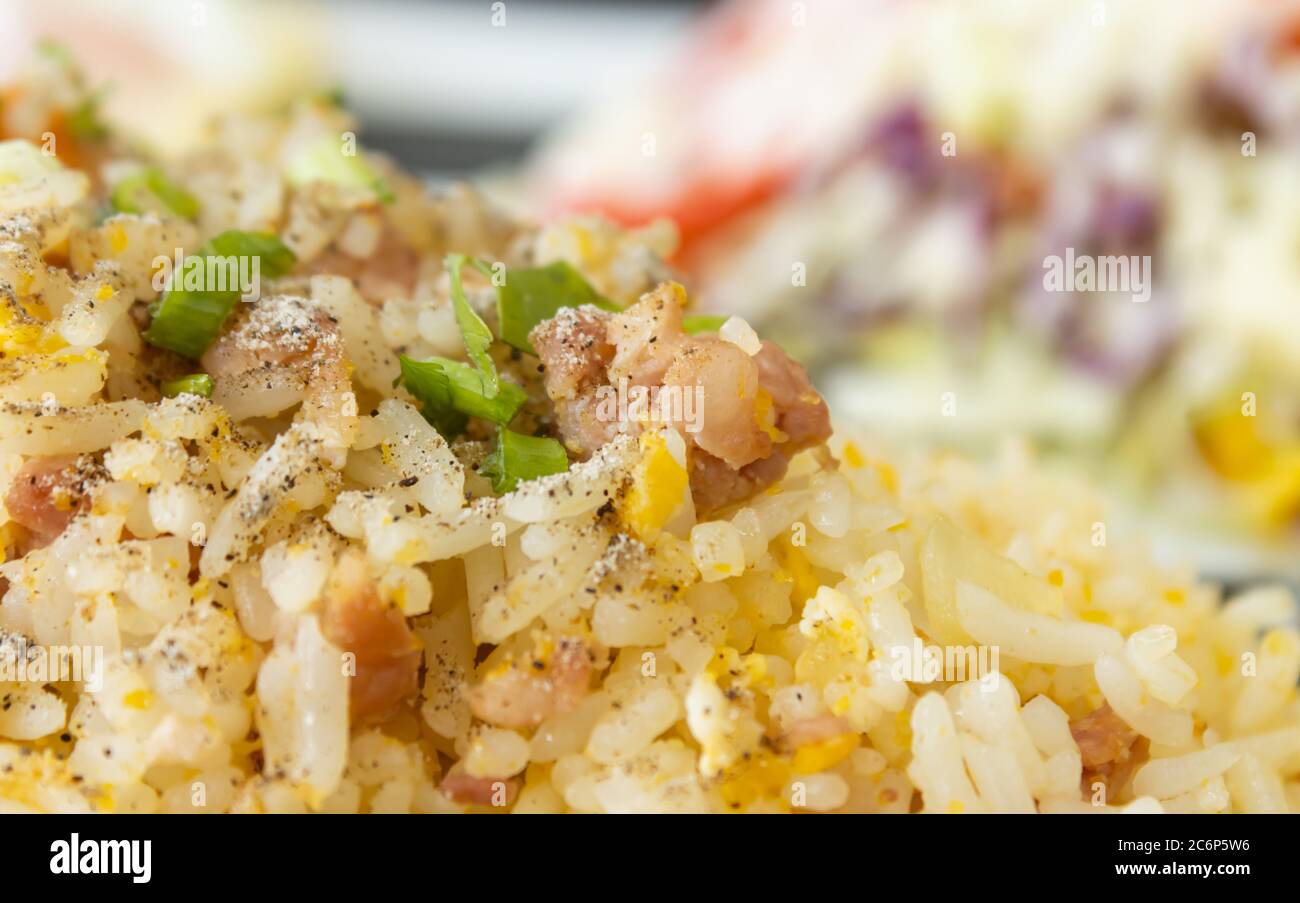 Thai Sour Schweinefleisch gebratener Reis und Salat in Gericht mit natürlichem Licht auf dem linken Rahmen Stockfoto