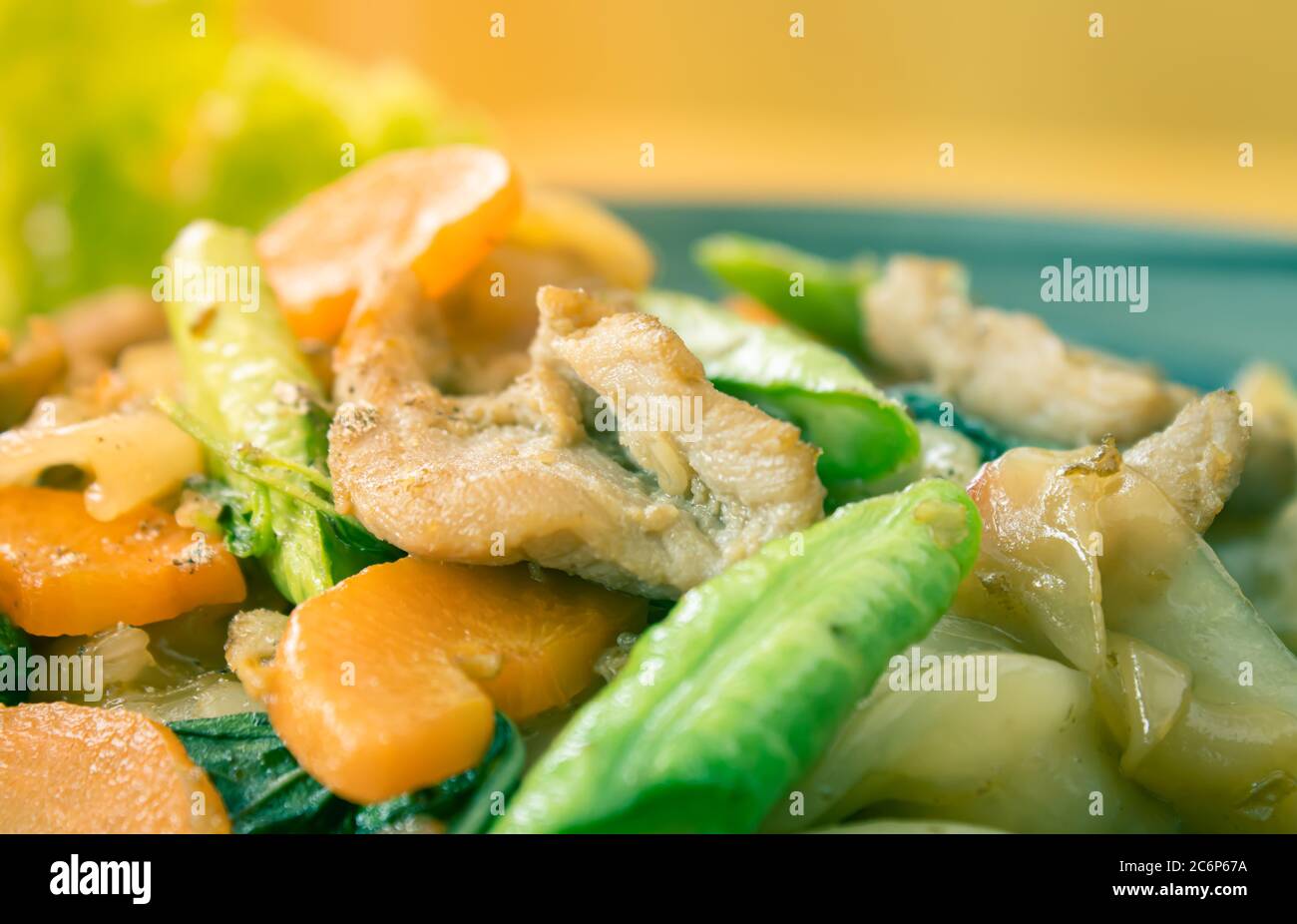 Gebratene Nudel und Schweinefleisch und Karotten und Yardlong Bohnen und Salat mit schwarzer Sojasoße mit natürlichem Licht im Zoom-Ansicht im Vintage-Ton umrühren Stockfoto