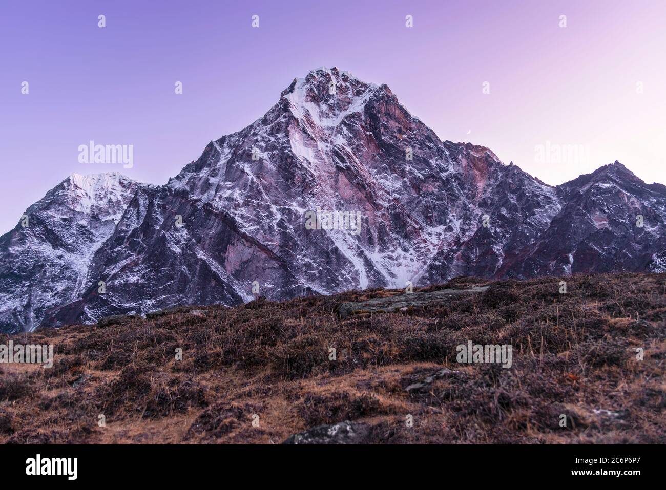 Die Wärme der Lodge lässt sich bei Dunkelheit verlassen, um den purpurnen Dunst über dem berüchtigten Cholatse-Gipfel im Himalaya in Nepal zu fangen. Stockfoto