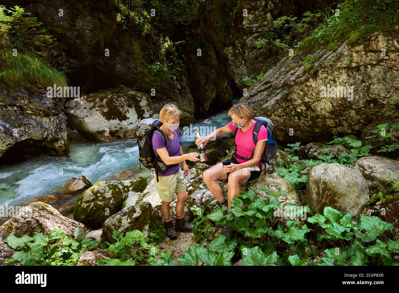 Zwei Frauen befolgen die Sicherheitsempfehlungen bei Outdoor-Aktivitäten. Trekking, covid-19, sichere Maske. Stockfoto